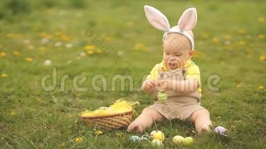穿着复活节兔子套装的幼儿在公园的<strong>草地</strong>上玩复活节彩蛋。 春季<strong>野餐</strong>，快乐